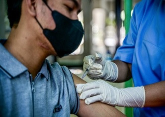 A health worker administers a dose of the locally made Inavac vaccine on Dec. 19, 2023, during a COVID-19 vaccination program at the Jakarta Health Office.