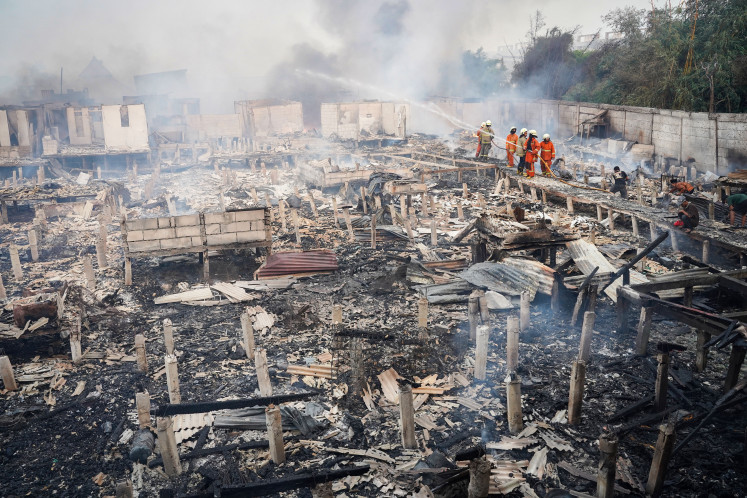 Firefighters extinguish flames that burned residents’ houses in Kapuk Muara, North Jakarta, June 6.
The fire broke out in a neighborhood largely made up of semi-permanent structures and was tackled by 29 fire trucks and 85 personnel.
